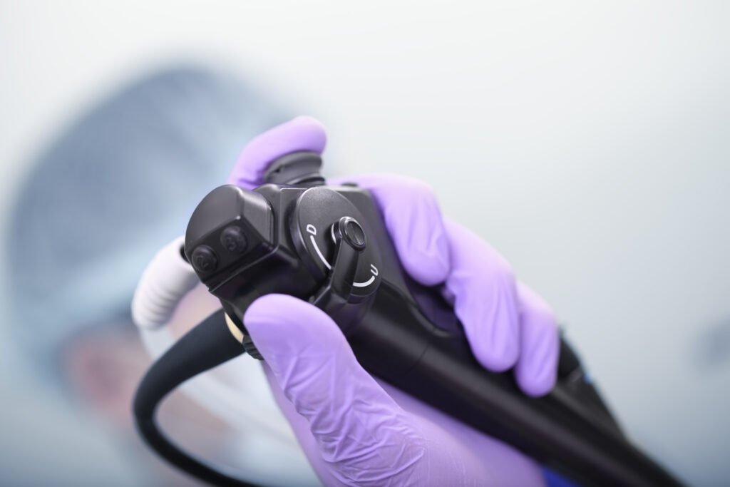 Bronchoskop in einer Hand mit einem Handschuh